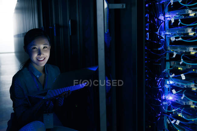 Smiling female technician inspecting in maintenance room at factory — Stock Photo