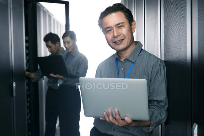 Pessoal técnico usando laptops e trabalhando na inspeção da sala de manutenção — Fotografia de Stock