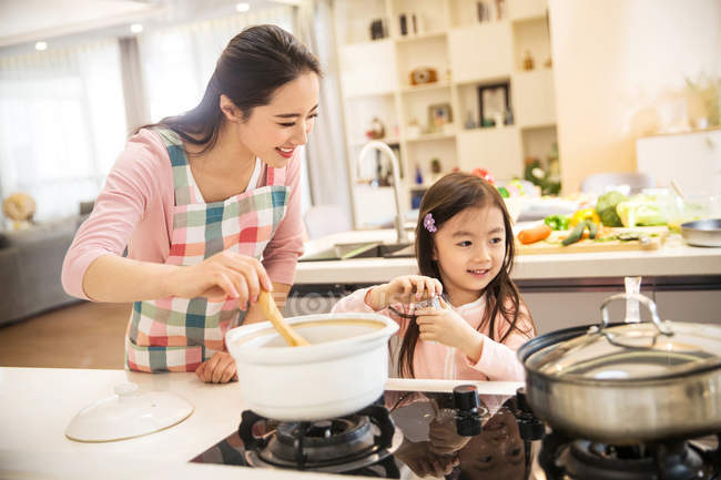 Feliz asiático mãe e filha cozinhar sopa juntos na cozinha — Fotografia de Stock