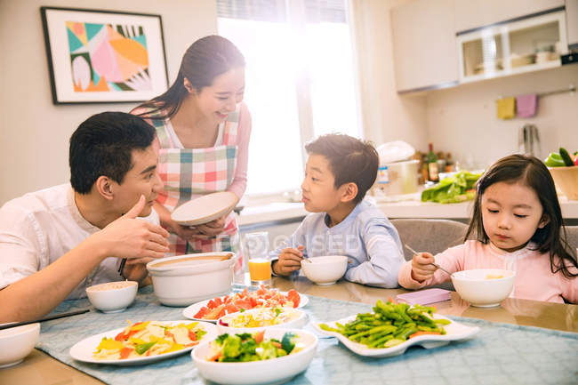 Feliz asiático familia con dos niños cenar juntos en casa - foto de stock