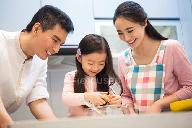 Happy young asian family with one kid cooking together in kitchen — Stock Photo