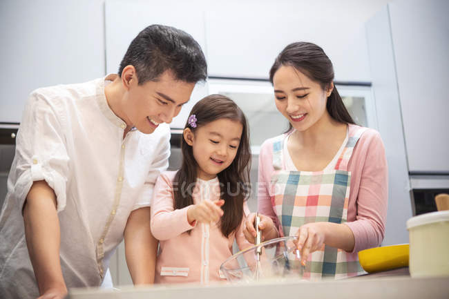 Happy asian family with one child cooking together in kitchen — Stock Photo