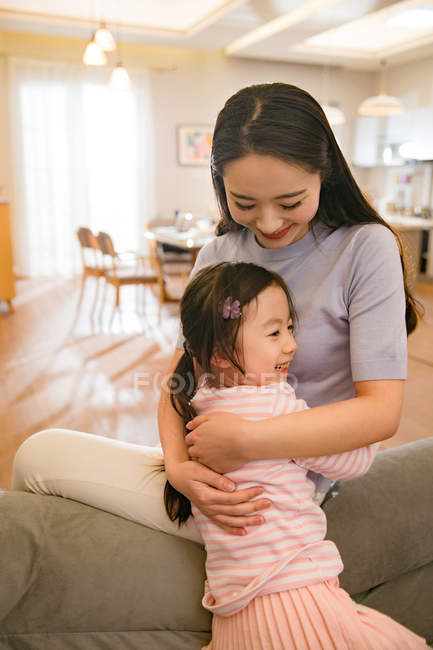 Beautiful happy asian mother and daughter hugging at home — Stock Photo