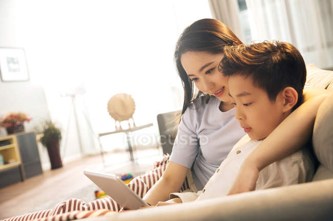 Feliz asiático mãe com filho usando digital tablet juntos em casa — Fotografia de Stock