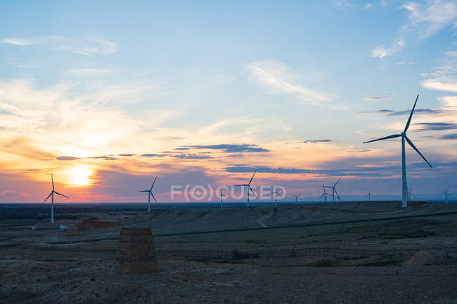 Wunderschöne Strandlandschaft mit Windmühlen bei Sonnenuntergang, Xinjiang, China — Stockfoto