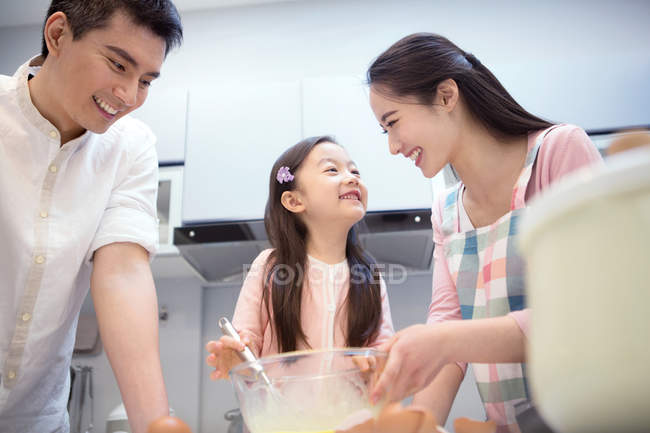 Щаслива азіатська сім'я з однією дитиною готує разом на кухні — стокове фото