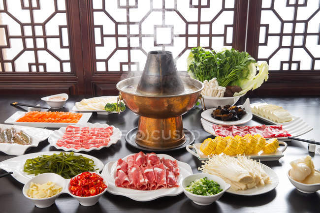 High angle view of various ingredients, chopsticks and copper hot pot, chafing dish concept — Stock Photo