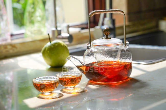 Vista de perto do conjunto de chá de vidro com chaleira e copos de vidro na mesa — Fotografia de Stock