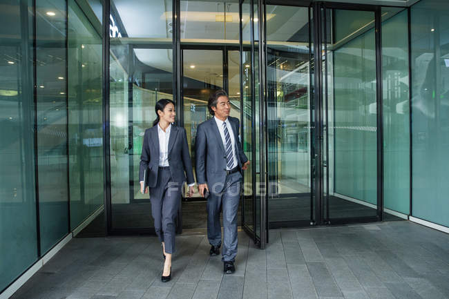 Азиатские бизнесмены, идущие в современном бизнес-центре — стоковое фото