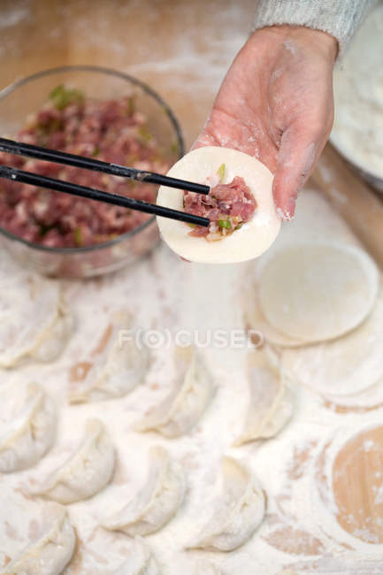 Colpo ritagliato di persona che prepara gnocchi tradizionali cinesi — Foto stock