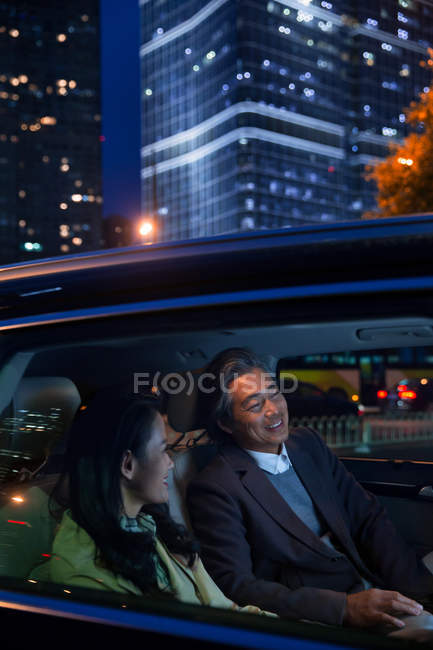 Felice coppia asiatica cavalcando in auto alla sera — Foto stock