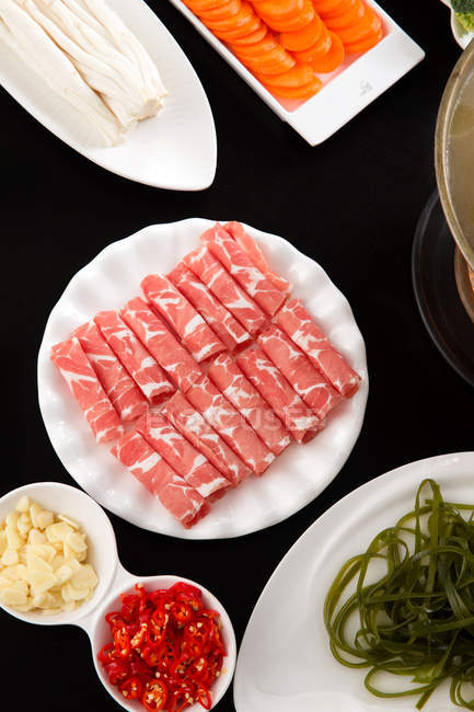 Vista dall'alto di carne affettata, verdure e pentola calda in rame, concetto di piatto irritante — Foto stock