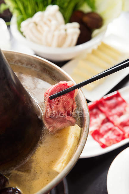 Крупным планом палочки для еды с горячим мясом и медью, концепция мясных блюд — стоковое фото