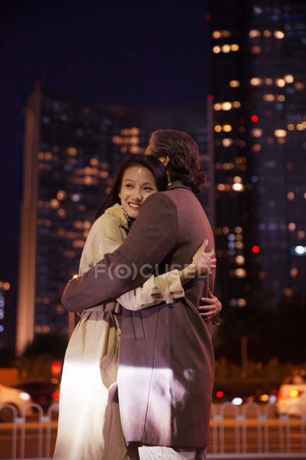 Happy asian couple hugging on street at evening — Stock Photo