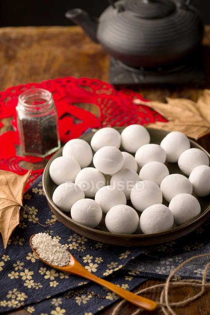 Bolas de arroz glutinoso chino tradicional y semillas de sésamo en la mesa - foto de stock