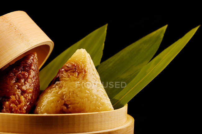 Vista de cerca del delicioso arroz glutinoso envuelto en hojas de bambú - foto de stock