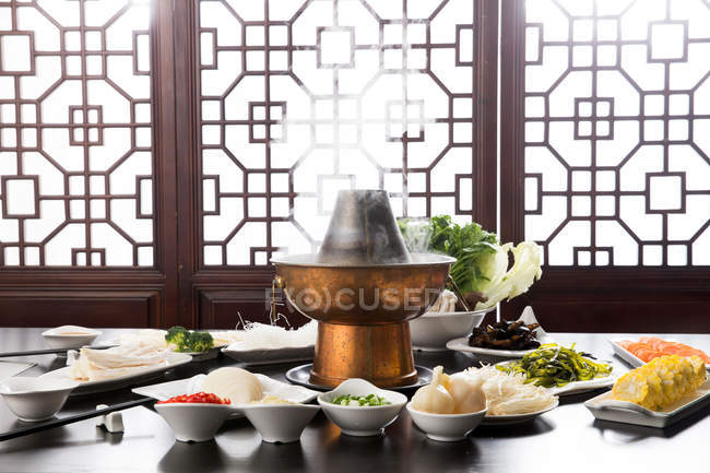 Various ingredients, chopsticks and copper hot pot, chafing dish concept — Stock Photo