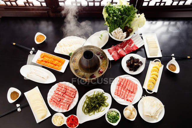 High angle view of various ingredients, chopsticks and copper hot pot, chafing dish concept — Stock Photo