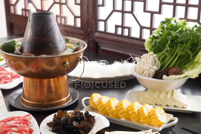 Carne, cogumelos, milho e vários ingredientes com panela de cobre quente, conceito prato de atrito — Fotografia de Stock