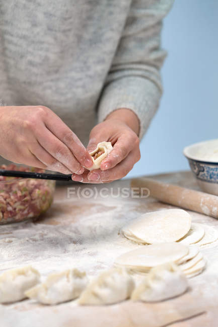 Обрезанный снимок человека, готовящего традиционные китайские пельмени — стоковое фото