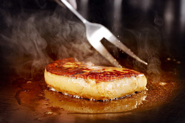 Vue rapprochée de la fourchette à viande et du processus de préparation de délicieux steak — Photo de stock