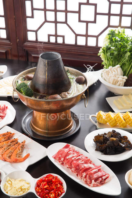 Kupfer Hot Pot, Fleisch, Gemüse und Meeresfrüchte auf dem Tisch, Scheuern Gericht Konzept — Stockfoto