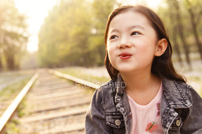 Portrait adorable asian kid grimacing near railroad — Stock Photo