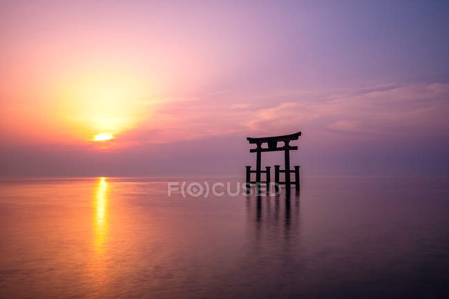 Torii dans le lac biwa avec un sanctuaire pendant le lever du soleil pittoresque — Photo de stock