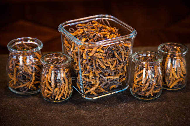 Visão de perto de Cordyceps sinensis saudável e seco em recipientes de vidro — Fotografia de Stock