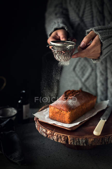Обрезанный снимок человека, просеивающего муку на свежем хлебе, процесс выпечки хлеба — стоковое фото