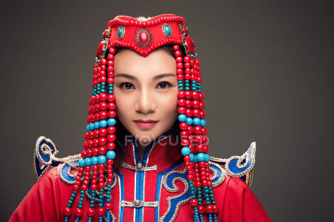 Hermosa mujer joven en el traje mongol mirando a la cámara - foto de stock