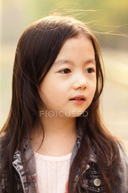 Portrait of adorable asian kid looking away outdoors — Stock Photo