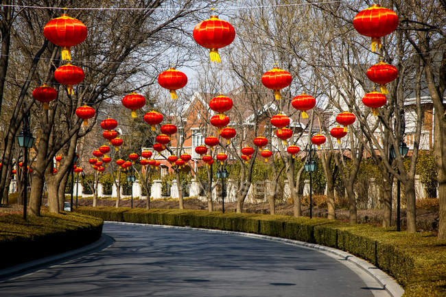 Lanternes chinoises rouges traditionnelles suspendues au-dessus de la route — Photo de stock