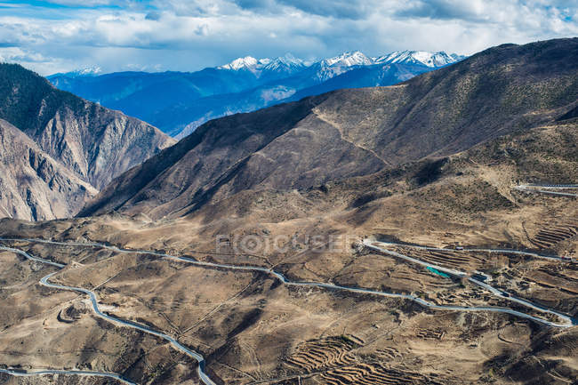 Vista aérea de la carretera sinuosa y las montañas escénicas, Tibet BaSu girar 72 paisaje de montaña - foto de stock