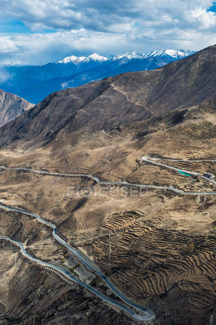 Vista aérea de la carretera sinuosa y las montañas escénicas, Tibet BaSu girar 72 paisaje de montaña - foto de stock