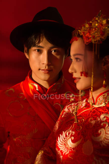 Beautiful happy young couple in traditional costumes at chinese classical wedding — Stock Photo