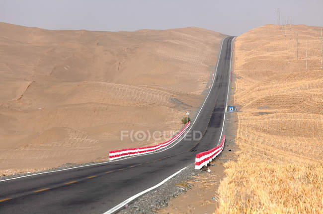 Autostrada del deserto dello Xinjiang nel deserto nella giornata di sole — Foto stock
