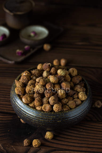 Vista close-up de deliciosos figos secos saudáveis na tigela na mesa de madeira — Fotografia de Stock
