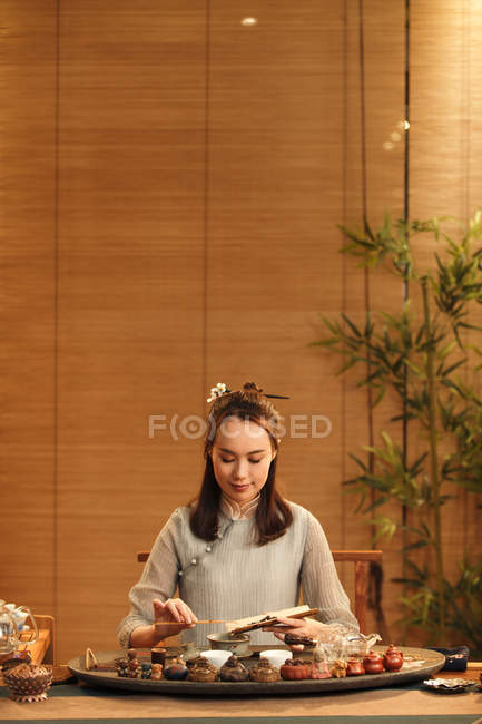 Красивая молодая китаянка в традиционной одежде делает травяной чай — стоковое фото