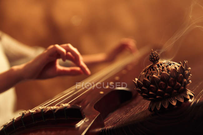 Tiro recortado de la mujer tocando instrumento guzheng chino tradicional, enfoque selectivo - foto de stock