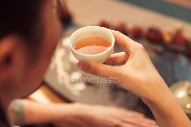 Primo piano vista di giovane donna asiatica in possesso di una tazza di tè — Foto stock