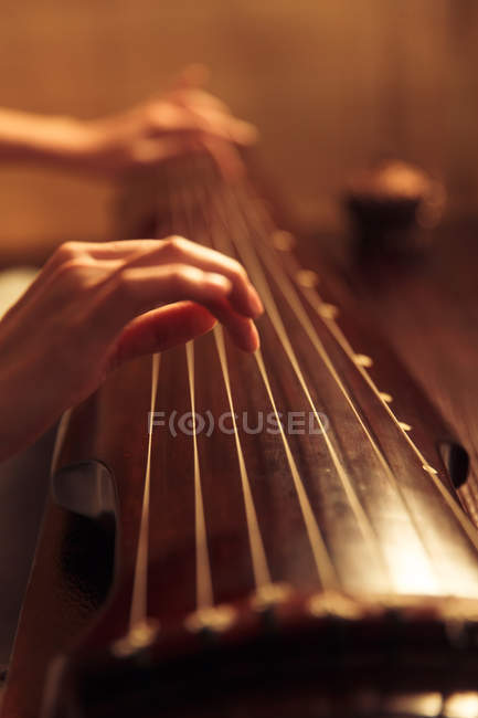 Cropped shot of woman playing traditional ancient chinese string instrument — Stock Photo