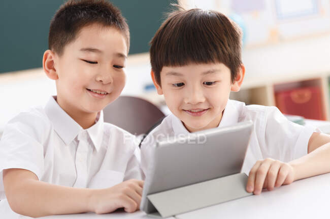 Deux étudiants utilisant une tablette numérique en classe — Photo de stock