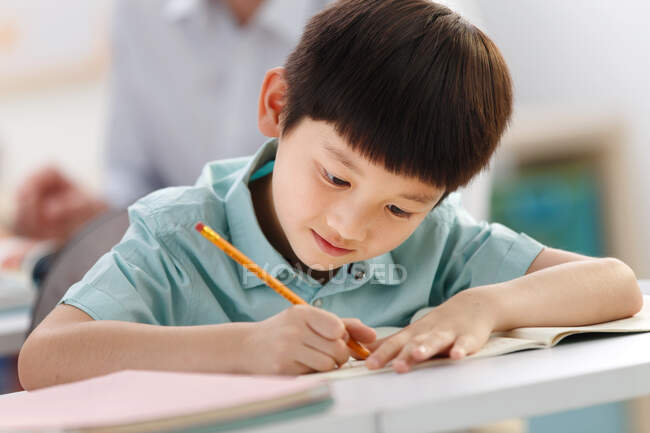 School boy studying in classroom — Stock Photo