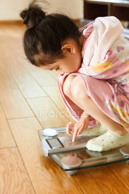Little girl on scale — Stock Photo