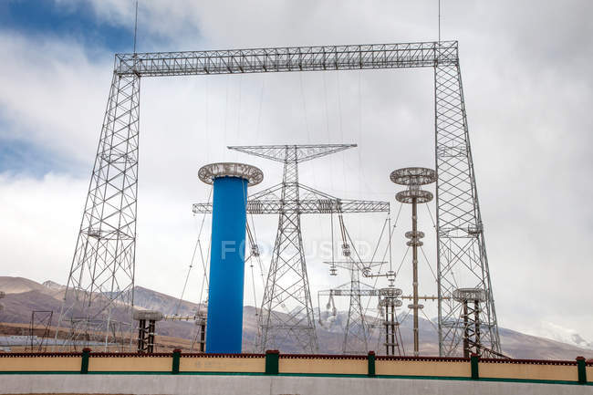 Vista de bajo ángulo de torres de electricidad y torres de comunicaciones en el Tíbet - foto de stock
