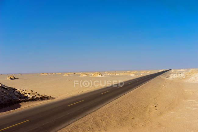 Camino de asfalto vacío en el desierto en el día soleado, Luobupo, Xinjiang, China - foto de stock