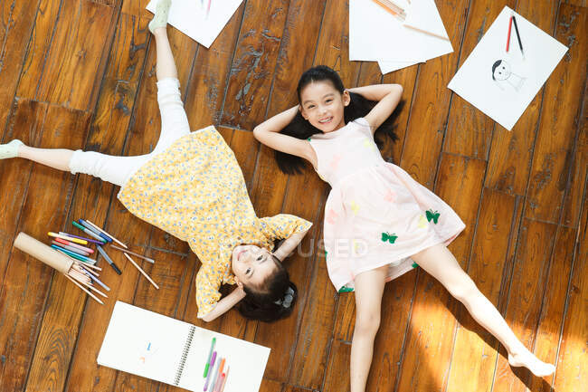 Две девушки лежат на полу на спине — стоковое фото