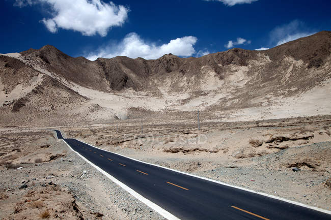 Leere Asphaltstraße und malerische Berge in Tibet — Stockfoto