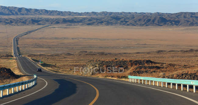 Visão de alto ângulo de estrada de asfalto e colinas no horizonte, Xinjiang, China — Fotografia de Stock